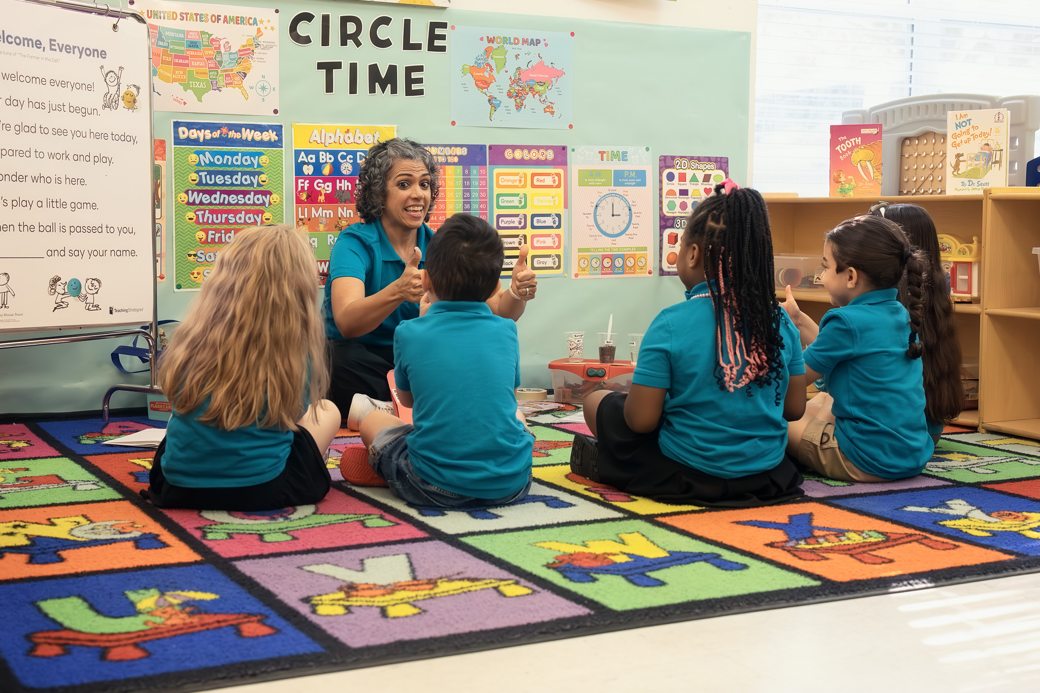 Children and teachers gathered in a circle on the grass