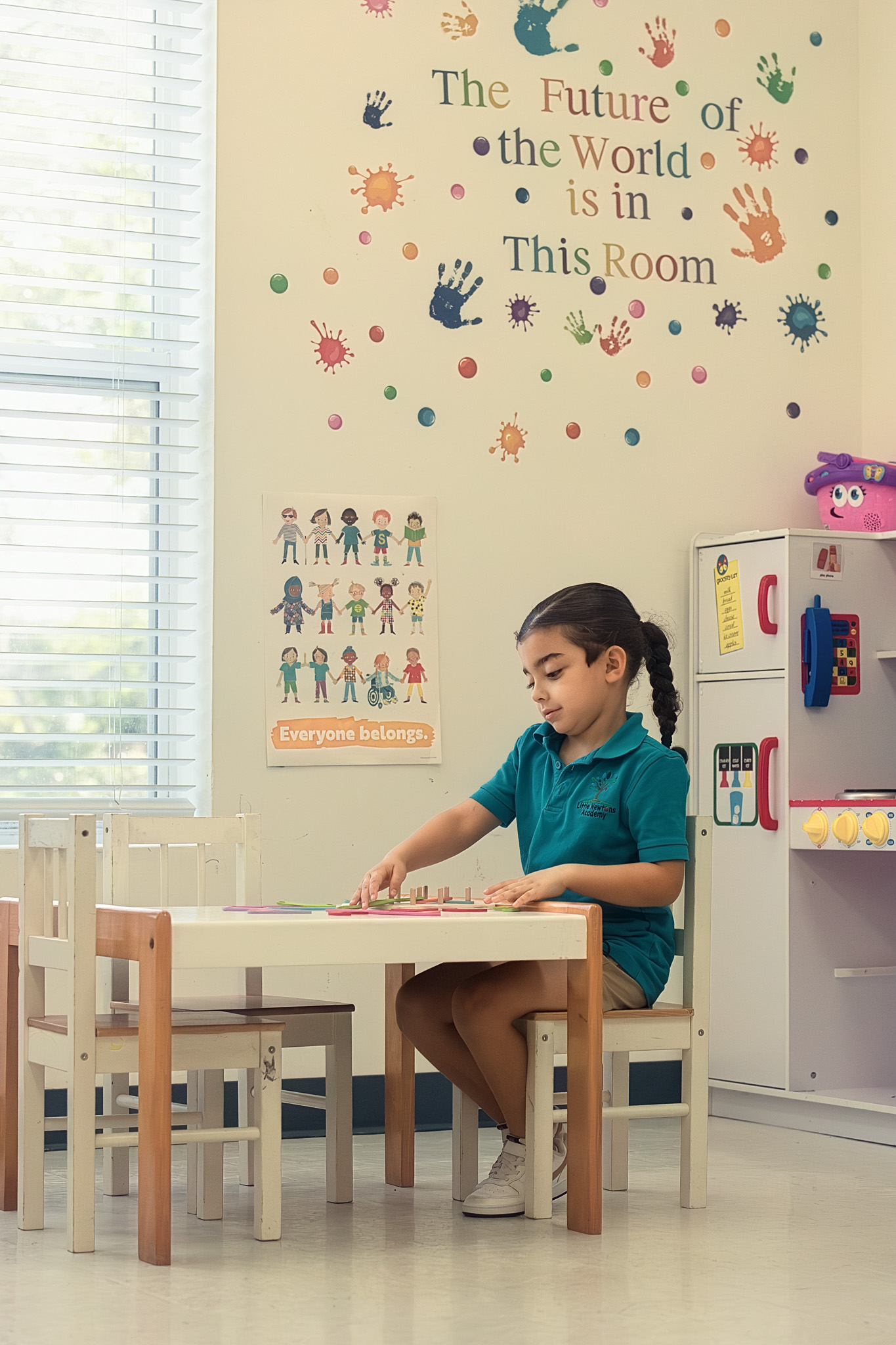 A student learning under 'The Future of the World is in This Room' classroom wall
