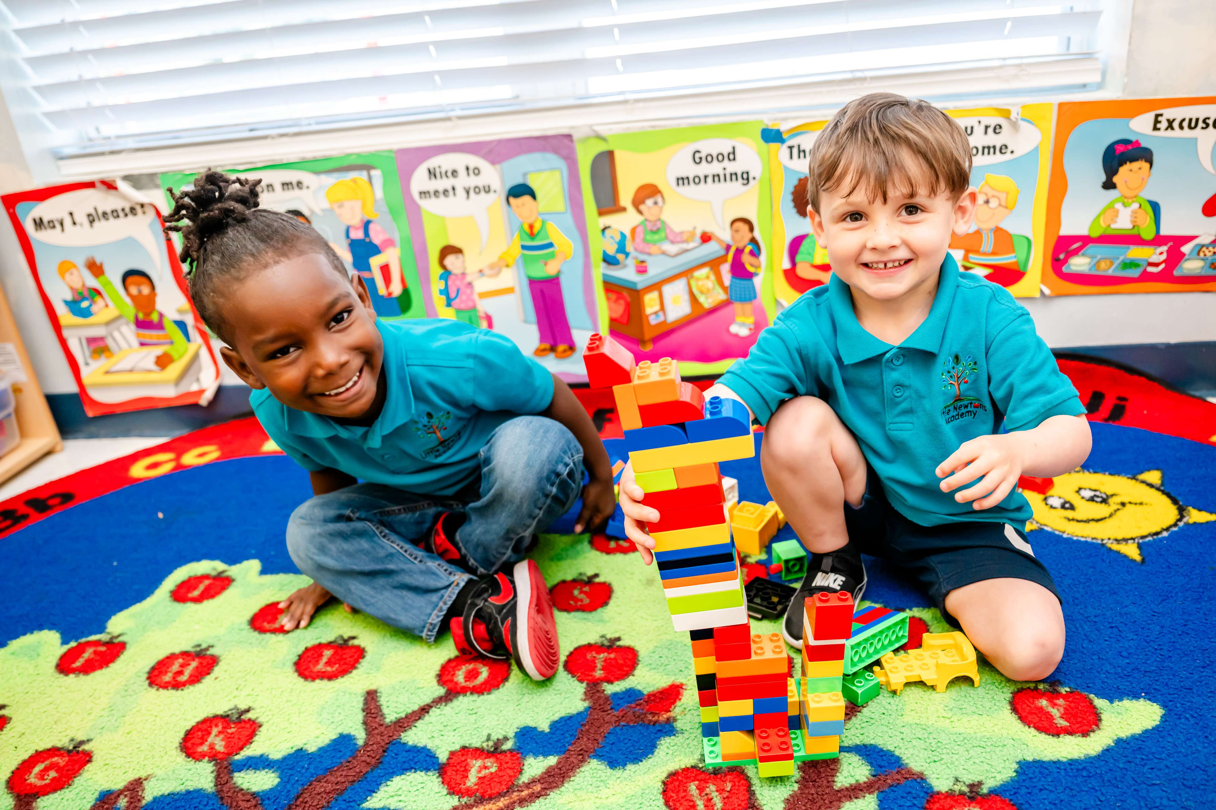 Two preschoolers building a tower with colorful blocks