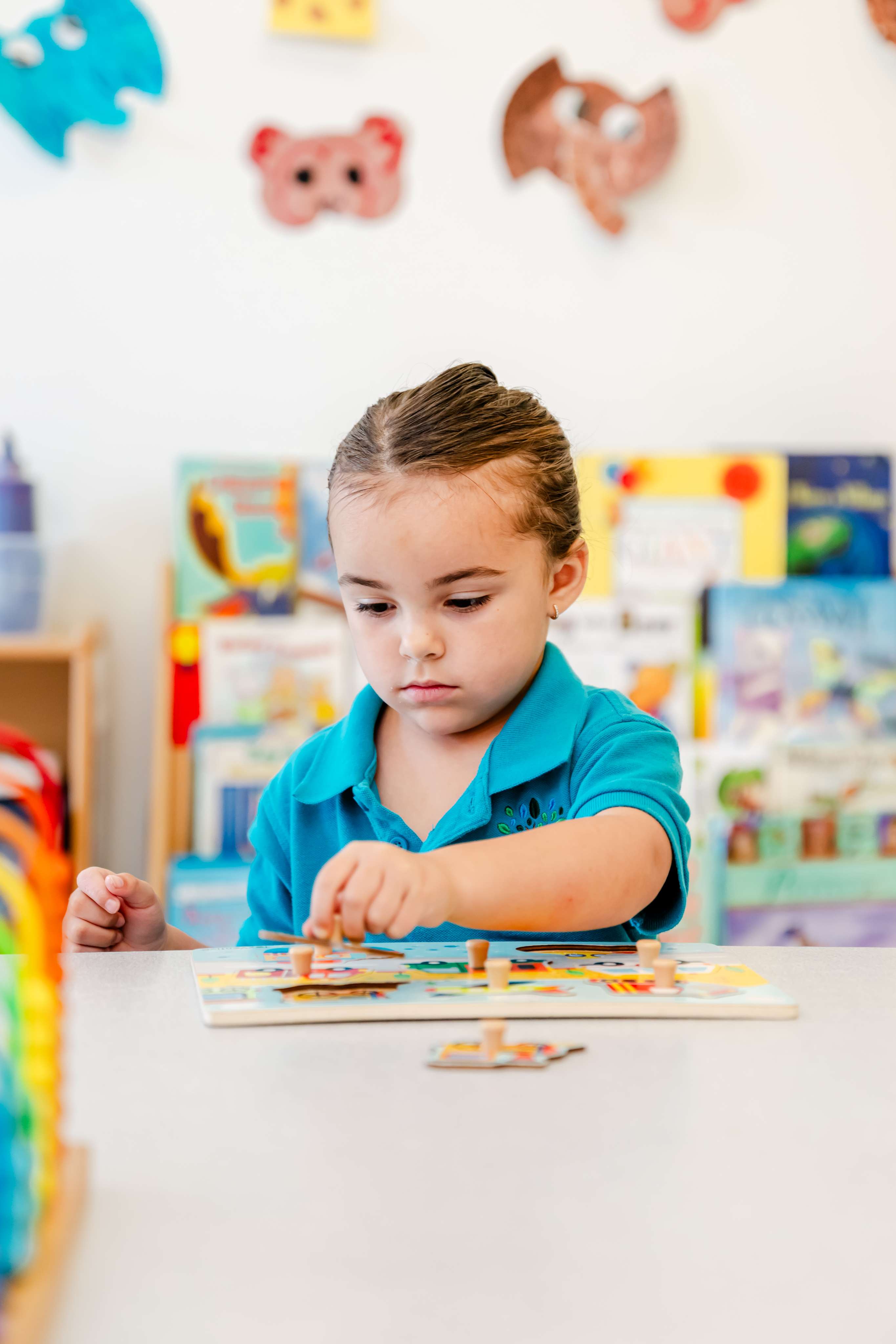 A focused preschool child completing a puzzle