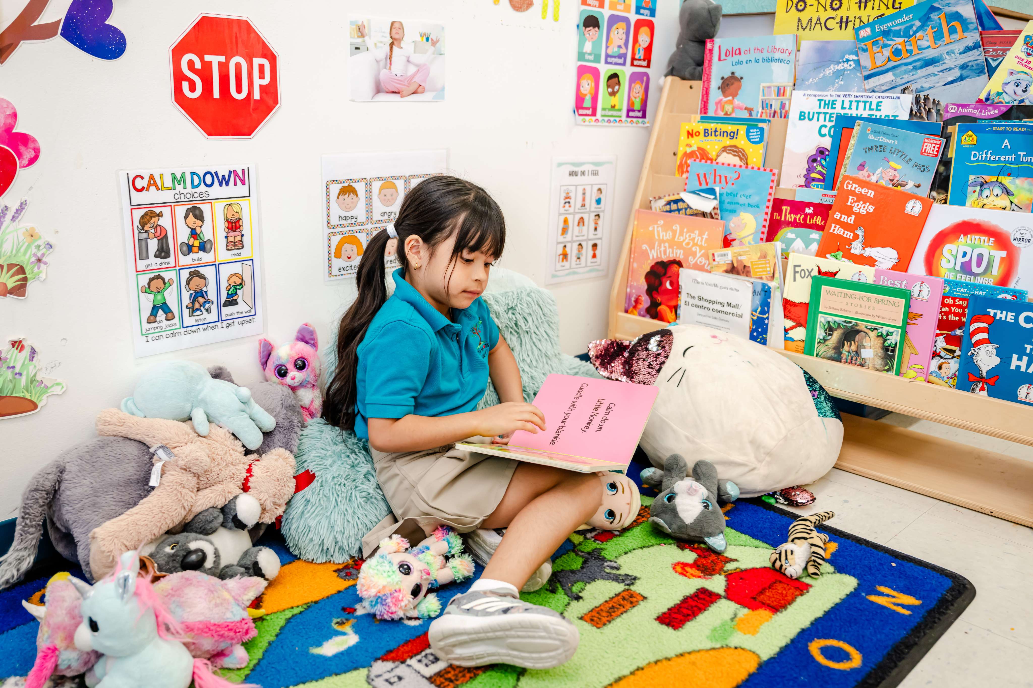 A child reading a book in the cozy classroom reading nook at Little Newtons Academy