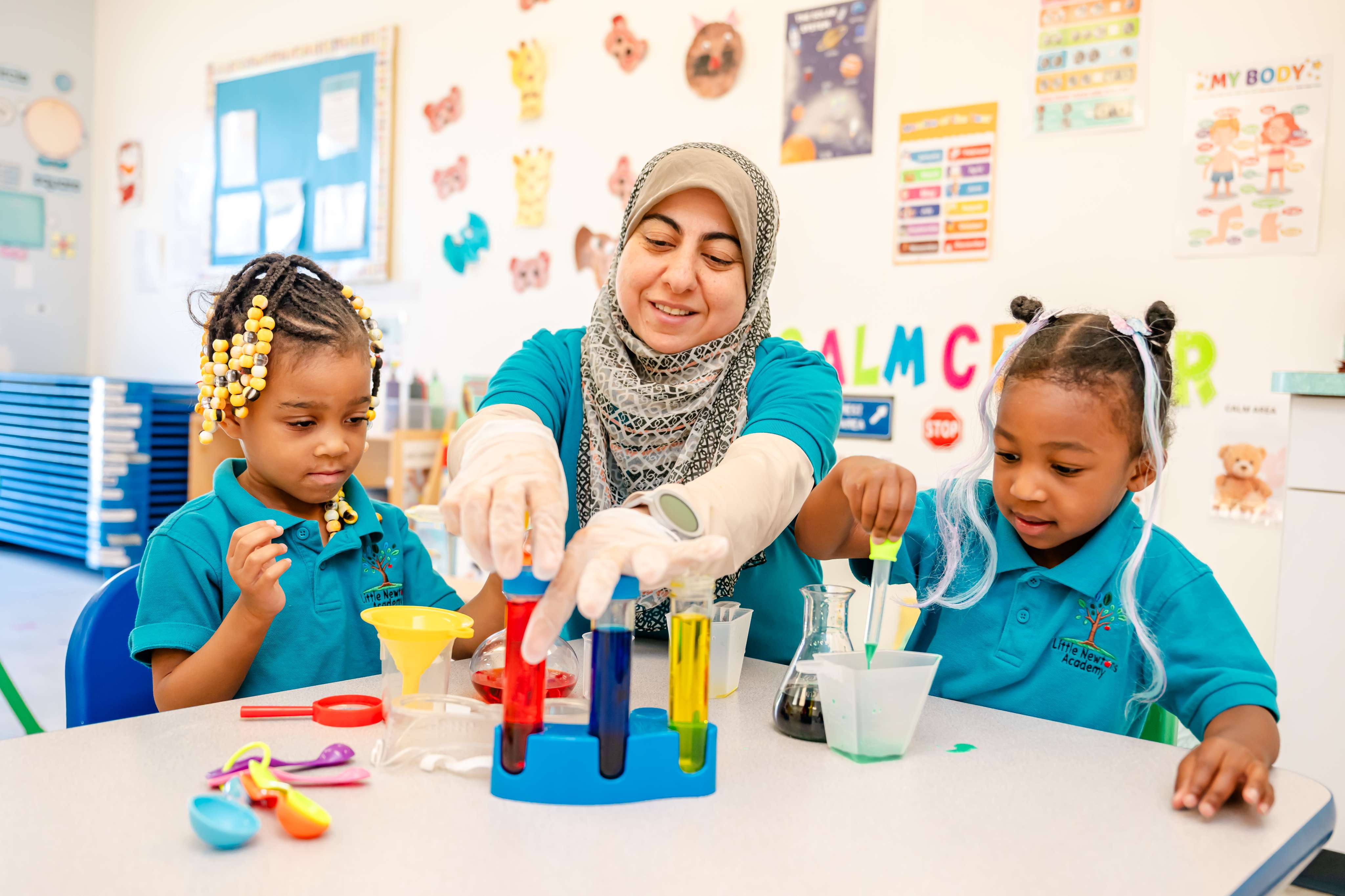 Teacher and children exploring a hands-on science experiment with colorful liquids