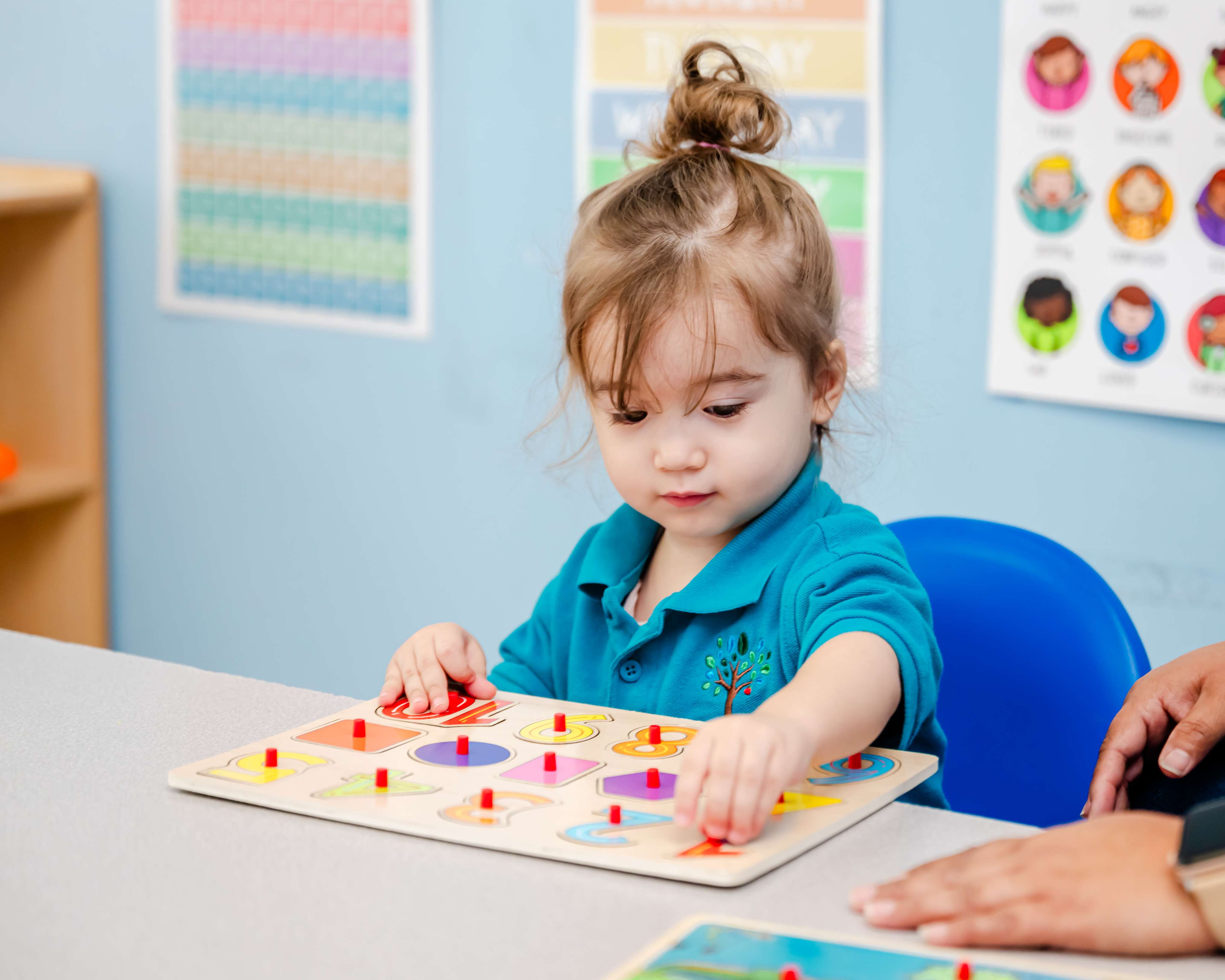 Toddler matching shapes at a learning table